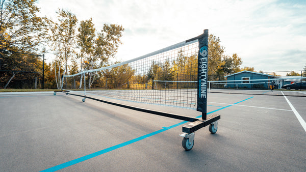 EIGHTYNINE Sports PX Tennis Net System installed on a residential backyard tennis & pickleball court.