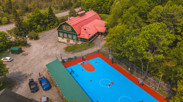 Painting Laykold Brick Red on a summer camp basketball court.