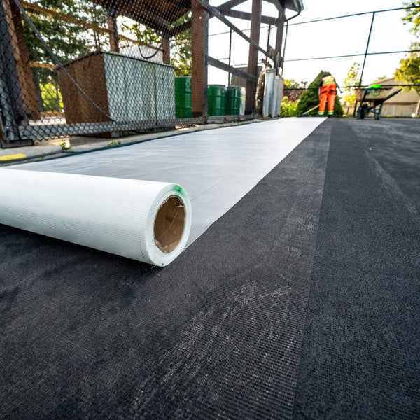 EIGHTYNINE Sports Fiberglass membrane being rolled out to adhere with acrylic resurfacer, reinforcing the acrylic coating.