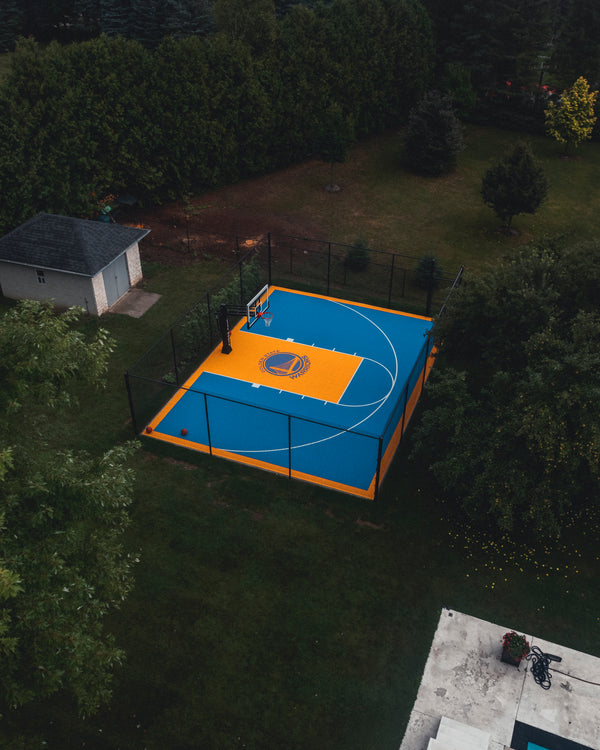 HEXPRO Sport Tile Basketball Court in Solar Yellow and Legacy Blue colorway with custom team logo & CITY Hoops Platinum Basketball Hoop.