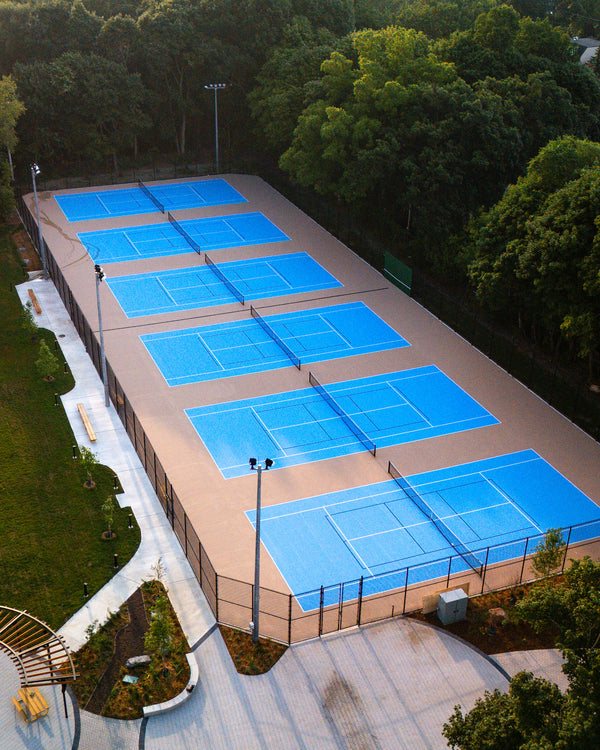 Private school tennis facility featuring six courts with EIGHTYNINE Sports tennis posts and nets.