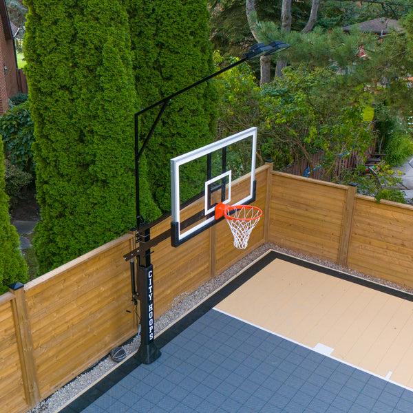 CITY HOOPS Gold System with pole-mounted LED lighting on a backyard basketball court.