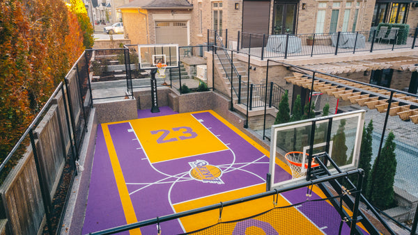 Two CITY HOOPS Platinum basketball systems installed on a modified full court in a residential backyard.