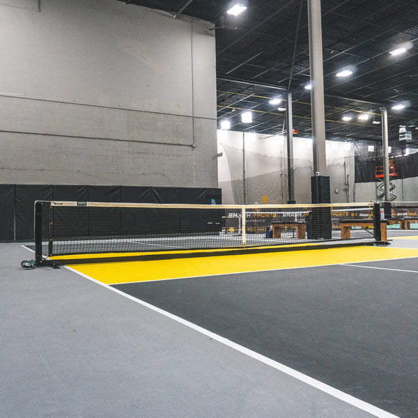 Semi-permanent EIGHTYNINE Sports Professional Pickleball Net System installed at an indoor pickleball facility.